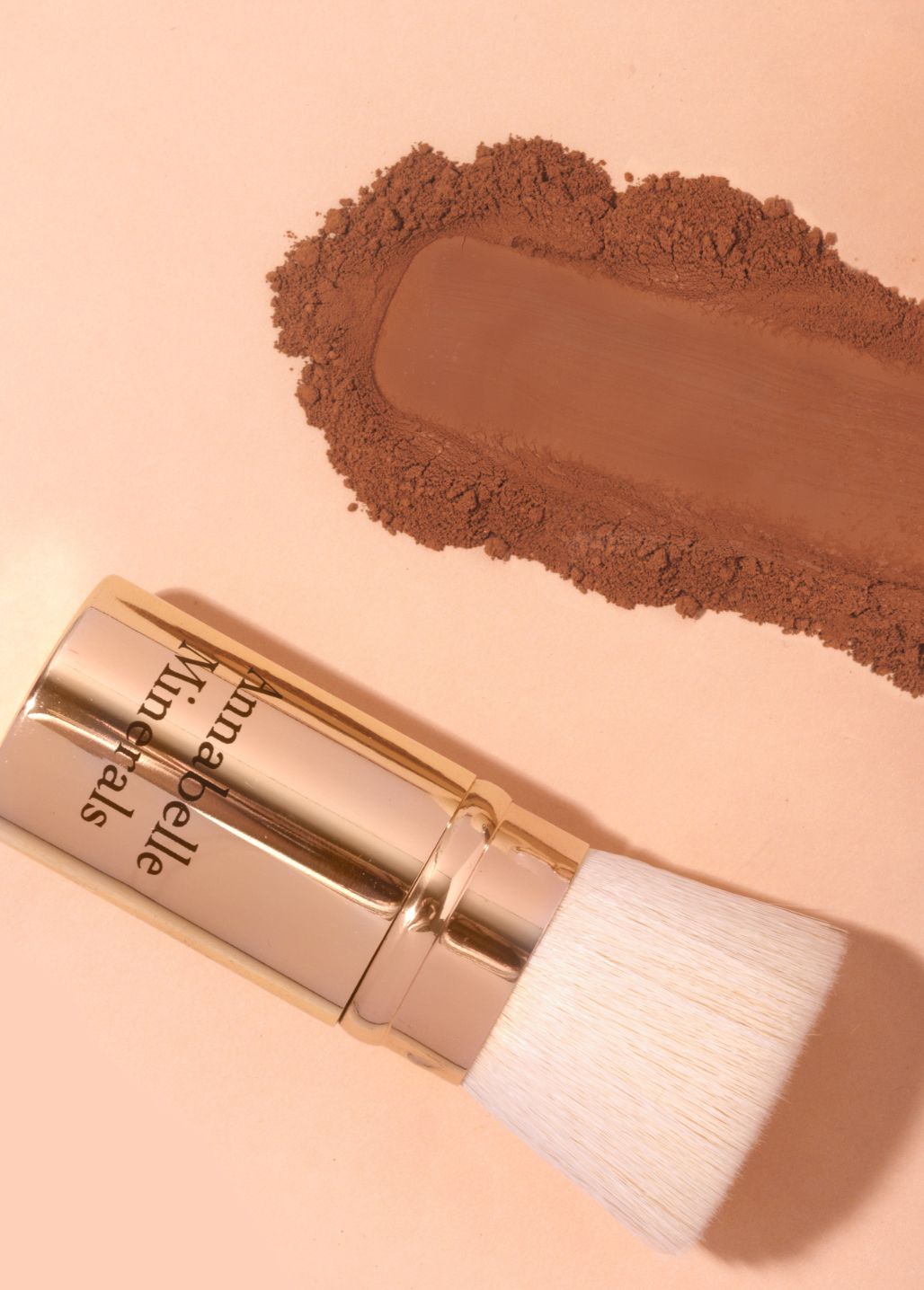 Podróżnych wysuwany pędzel flat top Annabelle Minerals, obok swatch koloru na neutralnym tle