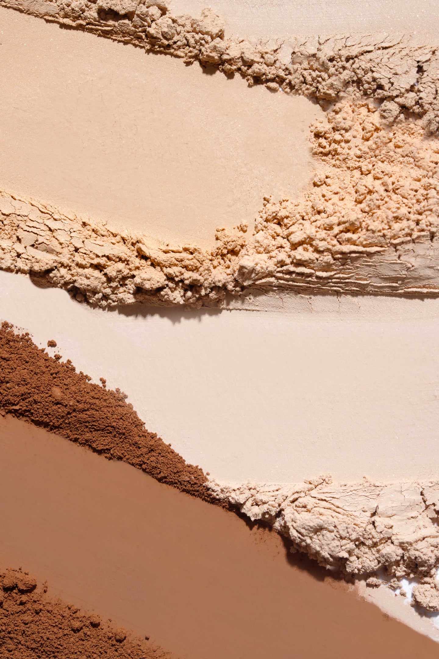Paleta różnych odcieni podkładów mineralnych do makijażu w tonach od beżowego do brązowego