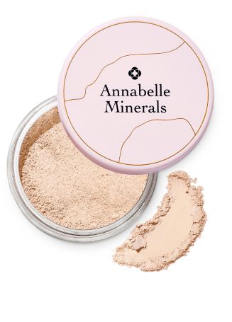 Opakowanie mineralnego korektora Annabelle Minerals z otwartą pokrywką i rozsypanym kosmetykiem obok